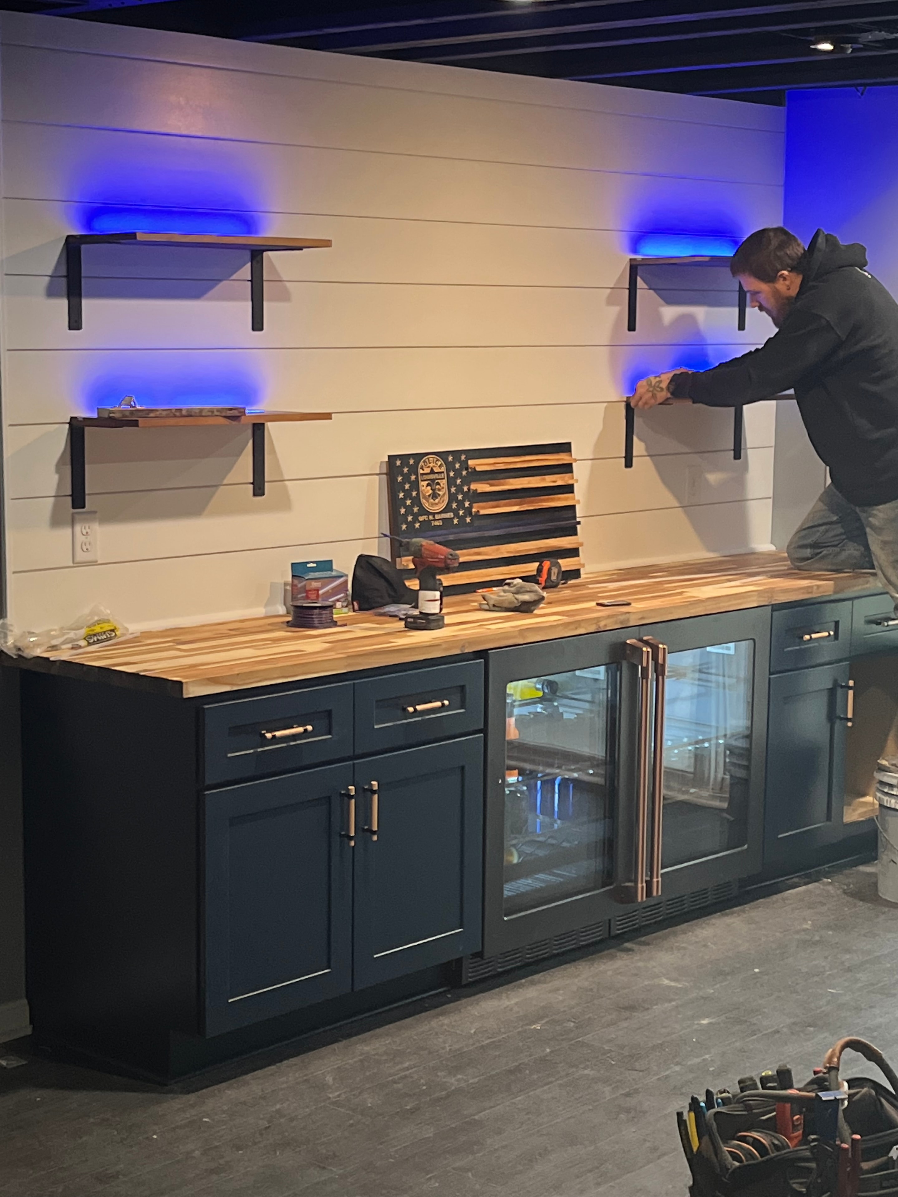 Technician installing under-cabinet LED lighting